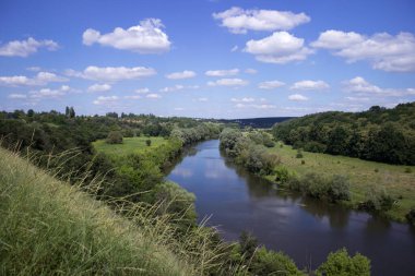 Vinnytsia yakınlarındaki güzel manzara, Güney Böcek nehri. Yaz, bulutlu gökyüzü. Ön planda çimler