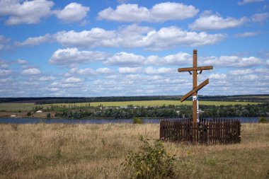Ukrayna, Vinnytsia bölgesi, Tokarivka köyü. Güzel manzara, güzel nehir manzarası hendek, çayır ve Hristiyan ahşap haçı.