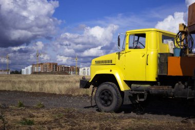İnşaat aracı, inşa edilen çok katlı binaların arka planında küçük bir vinçten yapılmış sarı bir kulübe. İnşaat konsepti