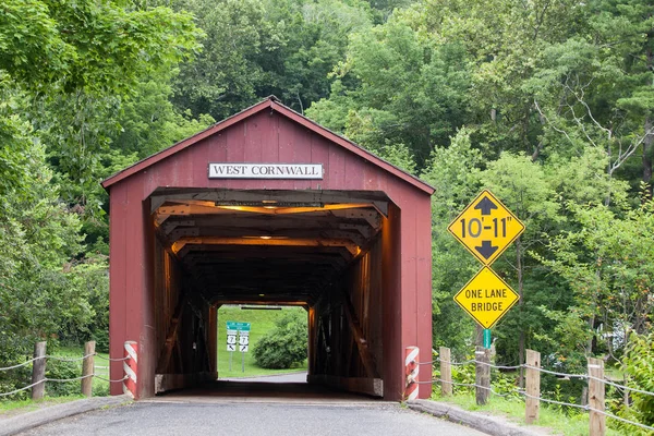 WEST CORNVALL, CONNECTICUT - JULY 15, 2015: The 1864 West Cornwall Covered Bridge  also known as Hart Bridge, is a wooden lattice truss bridge over the Housatonic River on July 15, 2015 in West Cornwall, CT, USA.