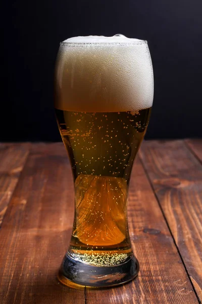 Tahta masada cam içinde bira.