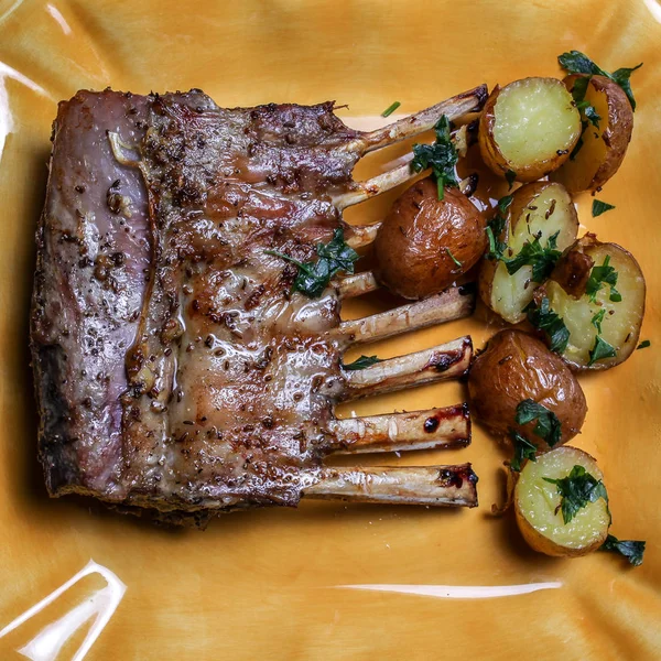 Costillas de cordero con patatas y perejil en la mesa — Foto de Stock