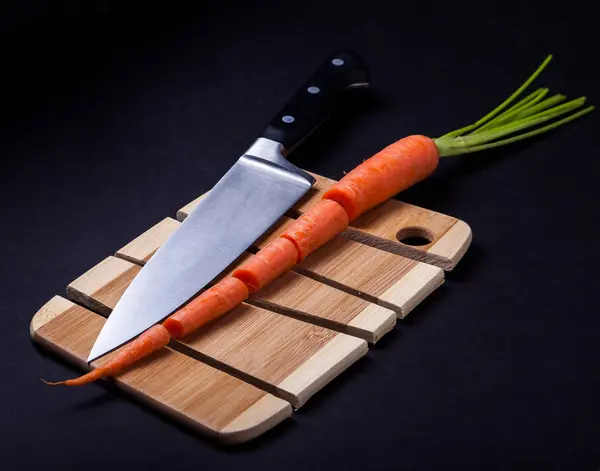 Coltello con carota e tagliere in legno — Foto Stock