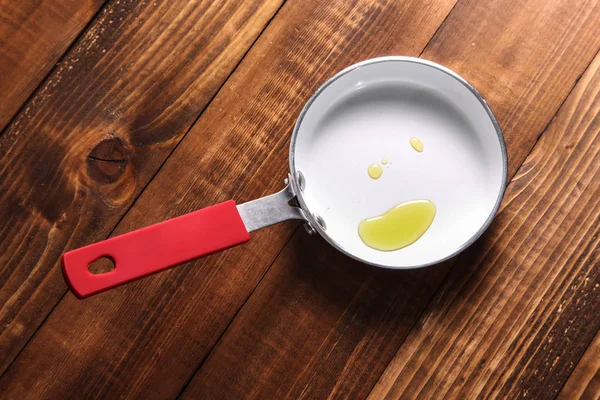 Fry pan with oil on wooden background — Stock Photo, Image