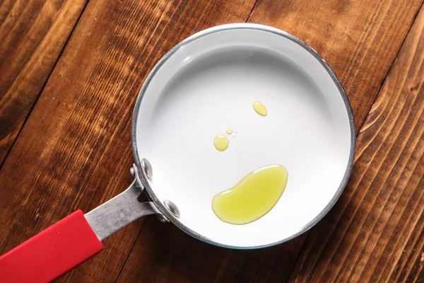 Padella con olio su fondo di legno — Foto Stock