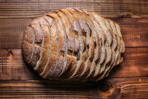 Pan en rodajas sobre fondo de madera — Foto de Stock