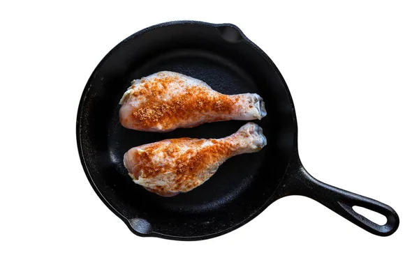 Iron skillet with chicken leggs and seasoning isolated on white — Stock Photo, Image