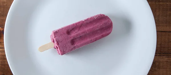 Blueberry ice pop on white plate