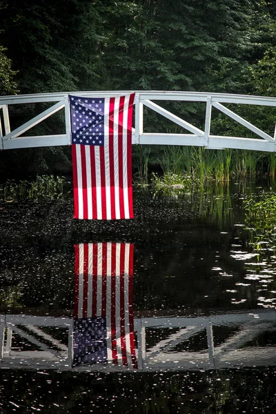 American flag hanging from wooden bridge in Somesville, Maine