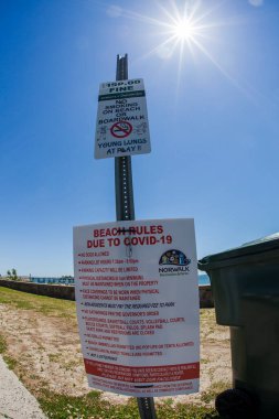 NORWALK, CT, ABD - 9 Haziran 2020: COVID-19 pandemik sırasında buzağı otlağı plajı hakkında bilgilendirme işareti