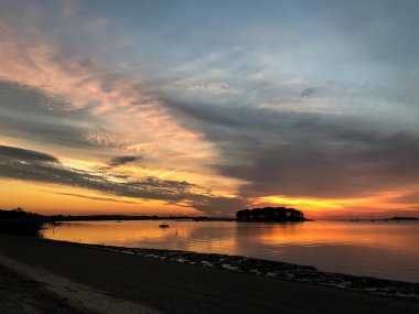 Sabah erkenden kumsalda Gökyüzünde güzel gündoğumu renkleriyle