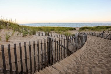 Cape Cod 'da kum tepeleri ve gökyüzü olan bir çit.