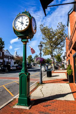 NEW CANAAN, CT, ABD - 4 EKİM 2020: Elm Caddesi 'nde saat, mağaza önleri, restoran ve mavi gökyüzü ile şehir merkezi