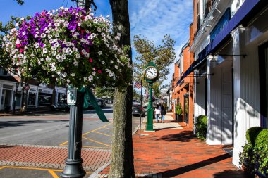 NEW CANAAN, CT, ABD - 4 EKİM 2020: Elm Caddesi 'nde saat, mağaza önleri, restoran ve mavi gökyüzü ile şehir merkezi
