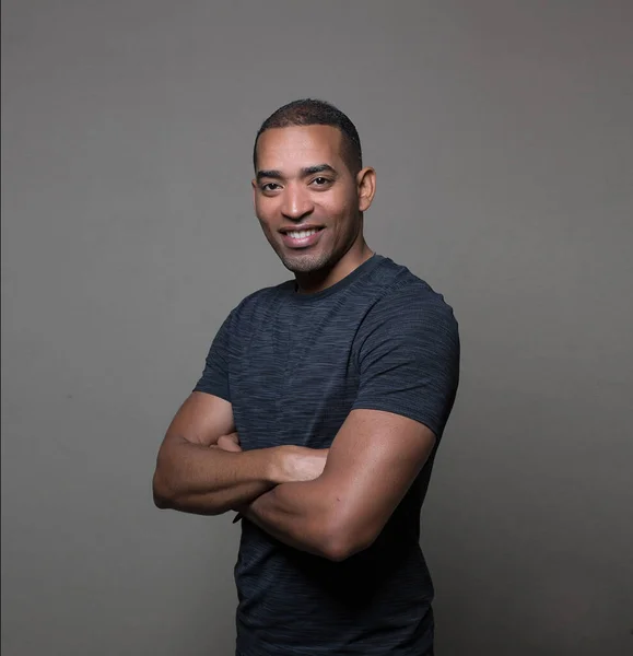 The portrait of a fit man in a t-shirt, fit and young man isolated on a grey background