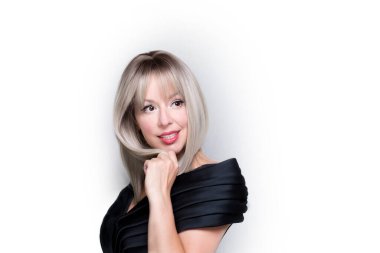 Sarışın, beyaz bir kadın, beyaz bir arka planda soyutlanmış, merak ediyor, düşünüyor, yan bakıyor.