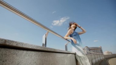 Yaz aylarında şehir caddesinde poz veren uzun elbiseli genç kız