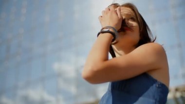 Cam bir gökdelenin önünde poz veren modelin portresi