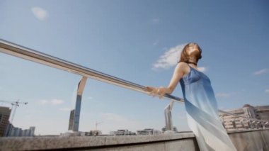 Yaz aylarında şehir caddesinde poz veren uzun elbiseli genç kız