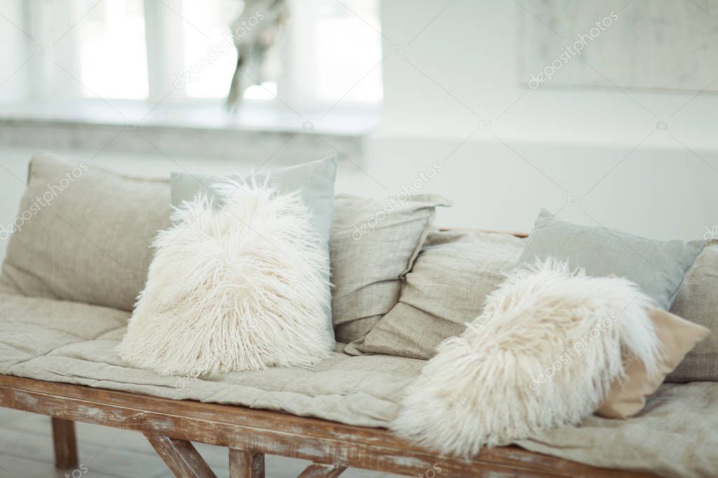 A self-made sofa with light soft pillows in a light-white interior