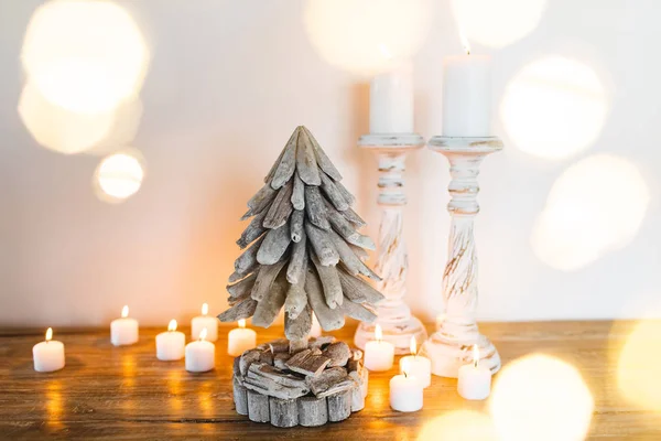 白い木製クリスマス ツリー装飾キャンドルと金色は 周りの光沢のあるライトをぼやけています テキストを配置します ハンドメイドのお祭りの概念 — ストック写真