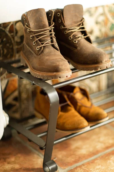 Autumn brown shoes and a backpack stand on a shelf in the hallway of the house