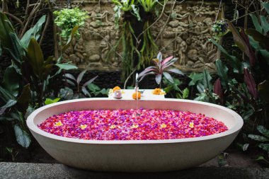 Lüks Otel banyo spa konsept 1küvet tropik yaprakları ile tropikal çiçeklerle, kırmızı ve pembe. Kendiniz için zaman.