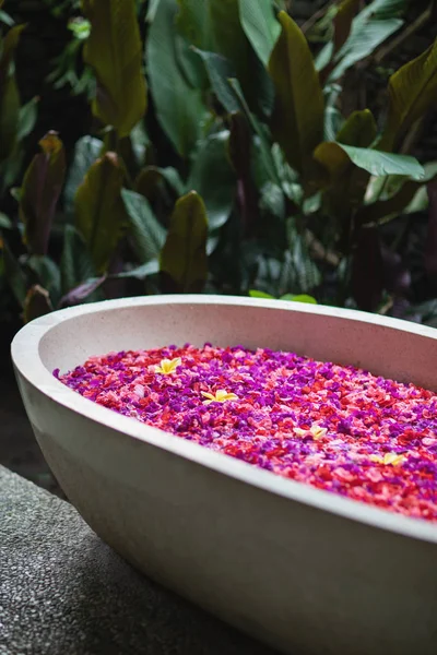 高級ホテルのバスルームと赤とピンクの熱帯花 熱帯の花びらを持つスパ概念バスタブ 自分のための時間 — ストック写真