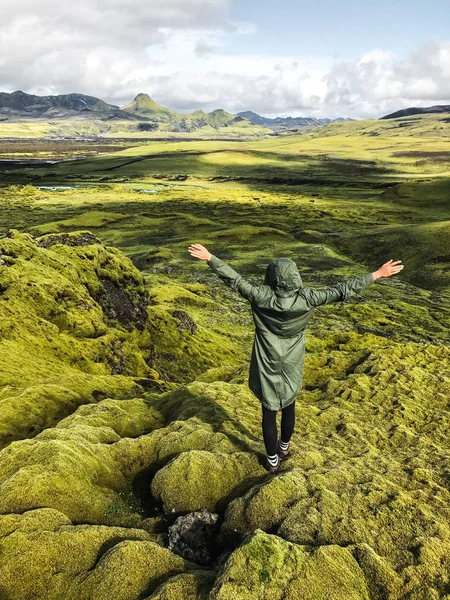 苔の景色を楽しみながら静かな女性覆われたアイスランドの牧草地です 北極圏野生の自然 人と自然の接続 快適防水緑のパーカーを着ている女性 — ストック写真