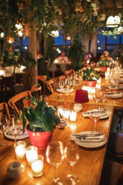 Hiçbir insan ile dekore edilmiş tablo görüntüsünü kapatın. Yemek masası plakaları, şarap, gözlük ve mum.