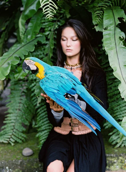 Ara papağan üzerinde genç çekici esmer kadın portresi — Stok fotoğraf