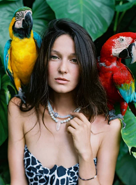 Porträtt av ung attraktiv brunett kvinna med ara papegojor på — Stockfoto