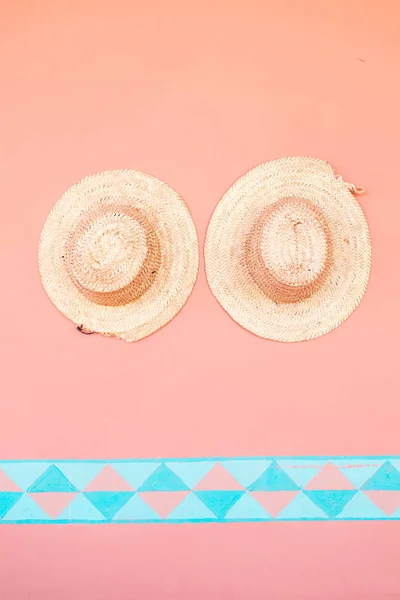 Straw beach hats  hanging on pink background. — Stock Photo, Image
