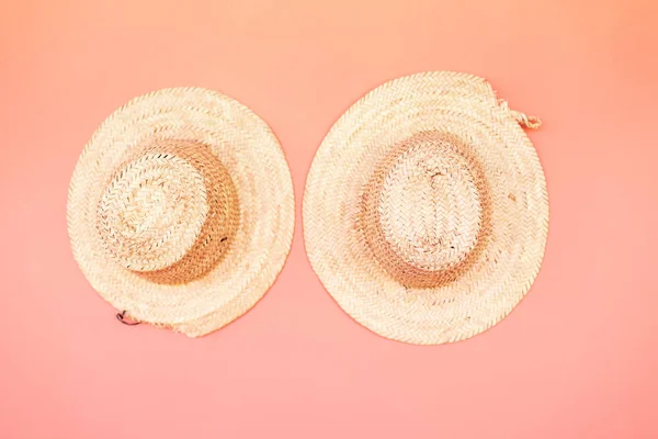 Straw beach hats  hanging on pink background. — Stock Photo, Image