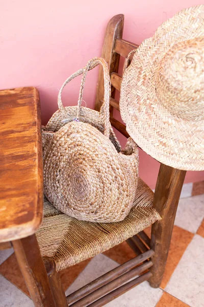 Stylish straw bag and hat on wooden rustic chair in room. Hello — Stock Photo, Image