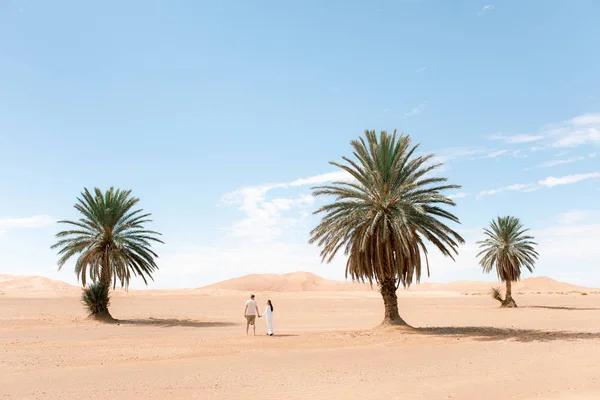 Jong stel wandelen in Sahara woestijn. Stockfoto