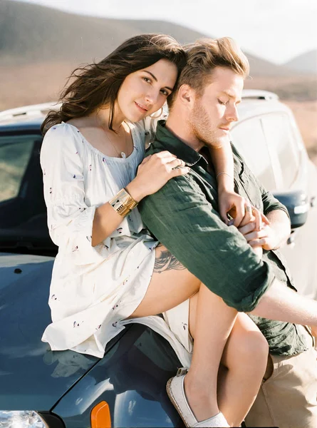 Couple sitting on the car. Stock Image