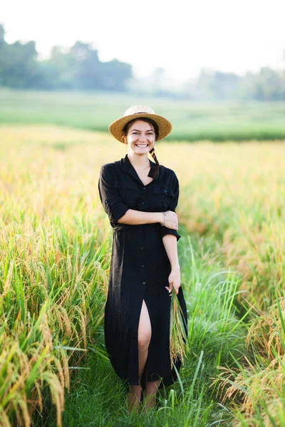 Woman in black dress and straw hat. — Stock Photo, Image