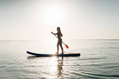 Paddle kurulu kadın paddleboarding Hawaii ayağa kalk. Karışık genç Asian beyaz kadın modeli Hawaii üzerinde yarış.