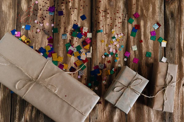 Dużo Prezentów Urodziny Leżą Drewnianym Stole Obok Siebie Pakowane Papier — Zdjęcie stockowe