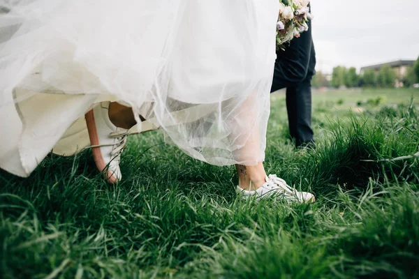 Наречений і наречений смішний і щасливий крок на траві — стокове фото
