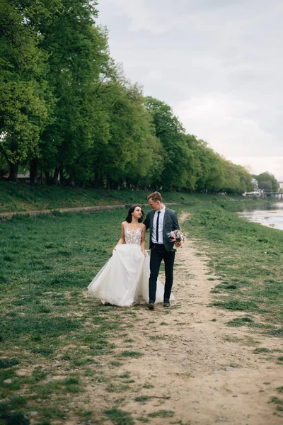 Наречений і наречений радісні і щасливі ходять в парку в день весілля — стокове фото