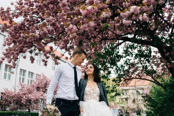 Lycklig brud och brudgum promenad på bröllopsdagen i parken. — Stockfoto