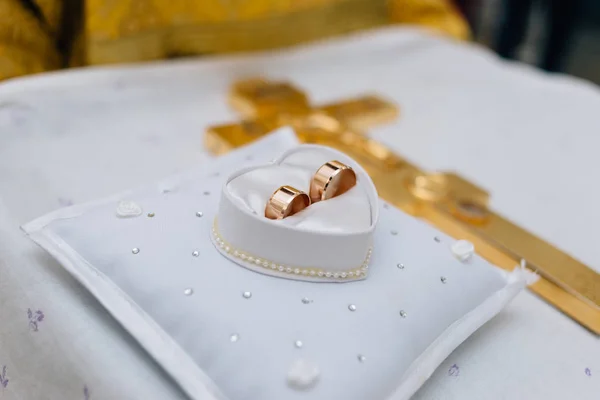 Anéis de casamento jazem no travesseiro ao lado um do outro — Fotografia de Stock