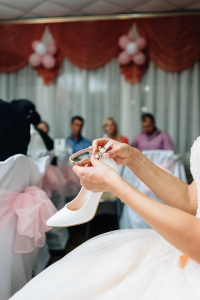 A noiva está usando sapatos brancos, a tradição no casamento para roubar sapatos — Fotografia de Stock