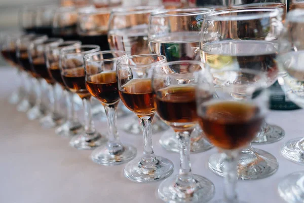 Beyaz bir masa örtüsü üzerinde bir restoranda bir masada alkol ile Gözlük