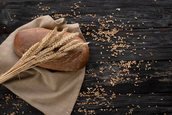 Baked goods lie on a wooden table. Ear of ripe wheat near — Stock Photo, Image