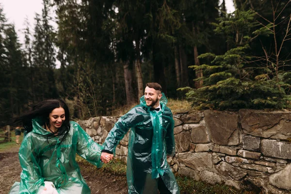 Boda de lluvia no es un obstáculo. Feliz novia y novio tener un divertido paseo en la lluvia —  Fotos de Stock