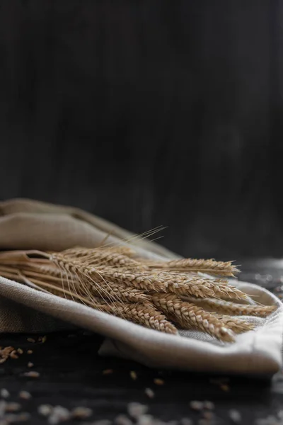 Buğday kulakları tahta bir masanın üzerinde yatıyor. Metnin altında bir yer var. — Stok fotoğraf