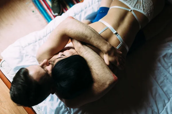 Nagi mężczyzna i kobieta leżą na łóżku. Delikatnie przytulić się nawzajem — Zdjęcie stockowe